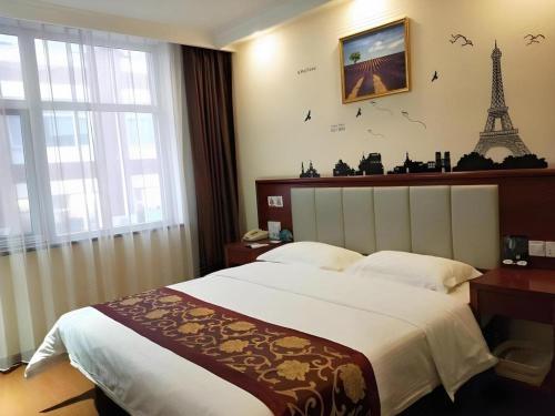 a bedroom with a bed with the eiffel tower on the wall at GreenTree Inn Yanjiao Haiyou Street Yanchang Road Express Hotel in Gaolou