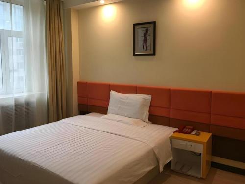 a hotel room with a bed and a table at 7 Days Inn Harbin Medical University First Affiliated Hospital in Harbin