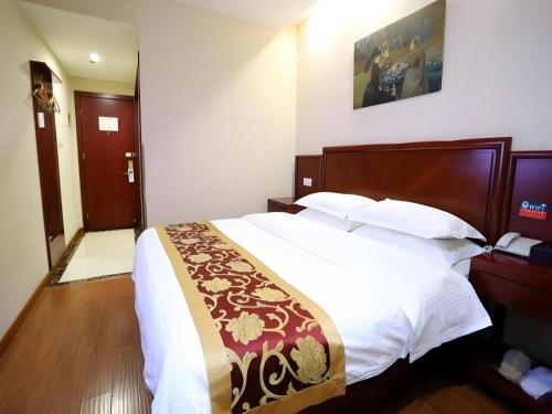 a bedroom with a large bed with a wooden headboard at GreenTree Inn Shanghai Jiading Newtown MaLu Subway Station Business Hotel in Jiading