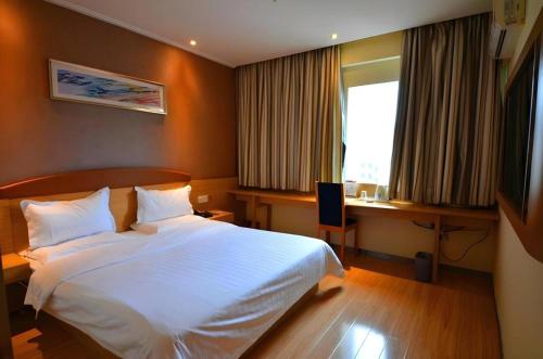a bedroom with a white bed and a desk and a window at 7 Days Premium Zunyi Conference Site Dingzikou in Zunyi
