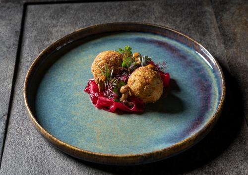 a blue plate with two meatballs on a table at Gut Sonnberghof in Mittersill