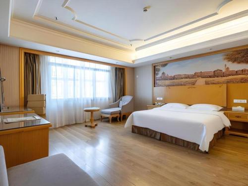 a hotel room with a bed and a large painting on the wall at Vienna International Hotel Lhasa Potala Palace in Lhasa