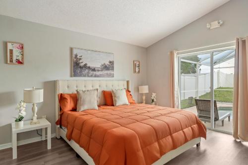 a bedroom with a bed with an orange comforter at Chic & Cozy Hideaway in Davenport