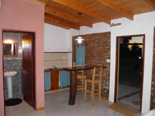 eine Küche und ein Esszimmer mit einem Tisch und Stühlen in der Unterkunft Posada de campo Mamúll Mapú in Rancul