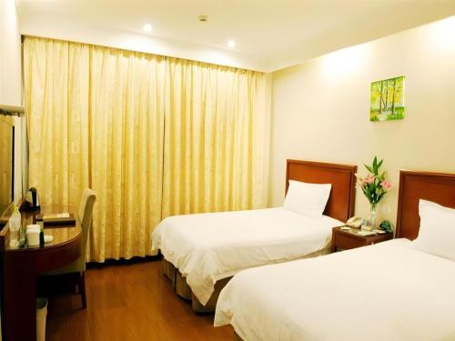 a hotel room with two beds and a desk at GreenTree Alliance Changzhou University City Hotel in Changzhou