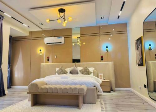 a large bedroom with a large bed and a chandelier at Damsel luxury apartment in Lekki