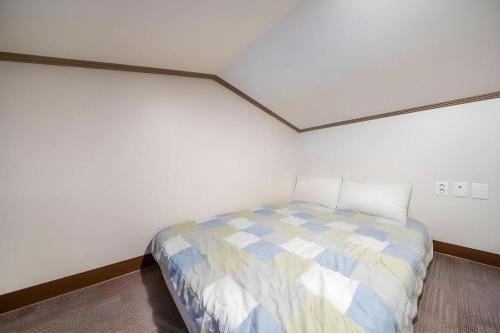 a bedroom with a bed in a white room at Sea View Hotel in Jeju