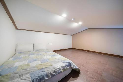 a bedroom with a bed in a white room at Sea View Hotel in Jeju