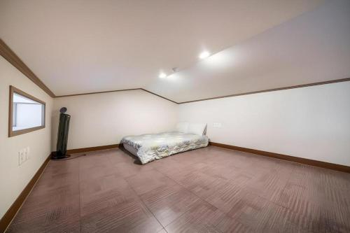 a bedroom with a bed in a room with a wooden floor at Sea View Hotel in Jeju