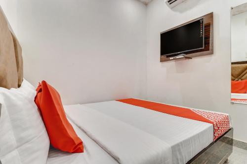 a white room with a bed and a flat screen tv at Hotel O Sun View in Ludhiana