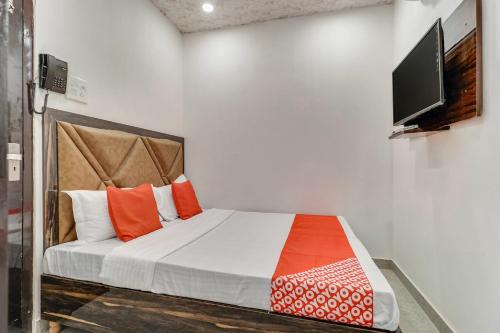 a bedroom with a bed and a flat screen tv at Hotel O Sun View in Ludhiana