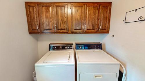 een wasmachine en droger in een keuken met houten kasten bij Lakeside Bliss in Hot Springs