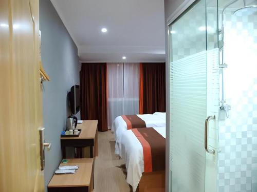 a hotel room with a bed and a glass door at Jun Hotel Jiangsu Nanjing Gulou District Gupinggang in Nanjing