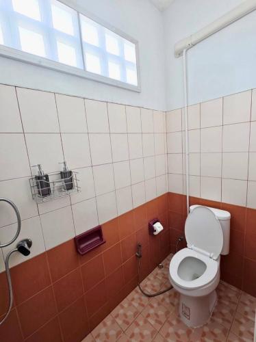 a bathroom with a toilet and a window at Nathamon House Hatyai in Hat Yai