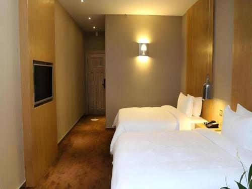 a hotel room with two beds and a television at The Art Hotel in Shenzhen