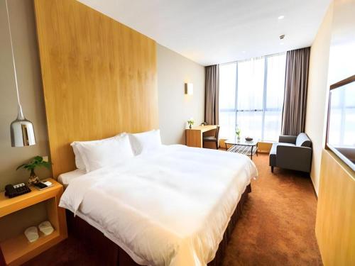 a hotel room with a large bed and a large window at The Art Hotel in Shenzhen