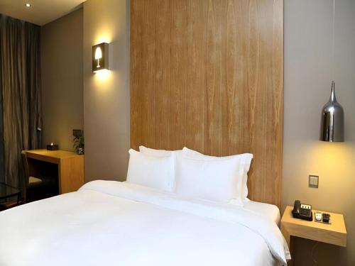 a large white bed in a hotel room at The Art Hotel in Shenzhen