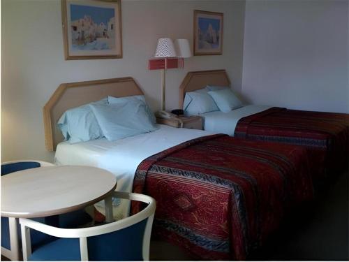 a hotel room with two beds and a small table at Americas Best Value Inn - Phoenix, AZ in Phoenix
