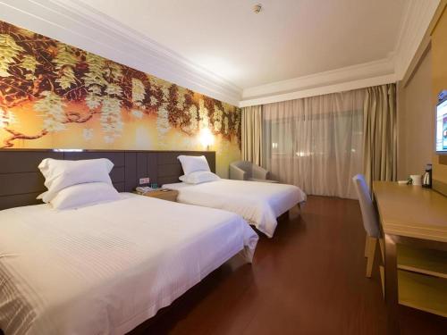 a hotel room with two beds and a desk at GreenTree Alliance Nantong Chongchuan Fangtian Market Branch in Nantong