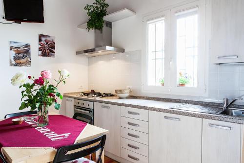 a kitchen with a table with a vase of flowers on it at Osteria da Cesare e Locanda in Castel San Pietro Terme