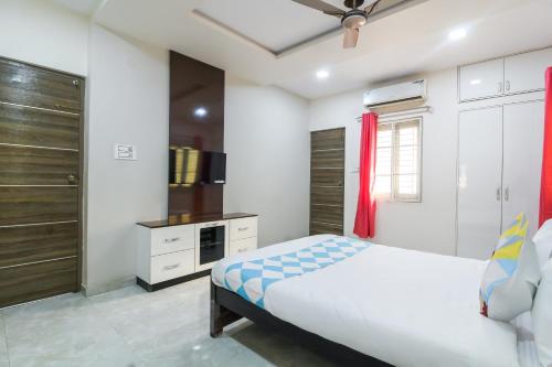 a bedroom with a large bed and a kitchen at Hotel O Home Dk Homes in Hyderabad