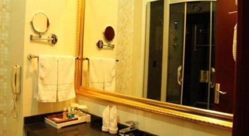 a bathroom with a large mirror and a sink at Tianrun International Hotel in Dunhuang