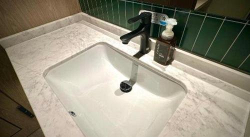 a sink with a faucet in a bathroom at Tianrun International Hotel in Dunhuang