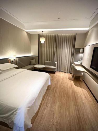 a hotel room with a large bed and a desk at Tianrun International Hotel in Dunhuang