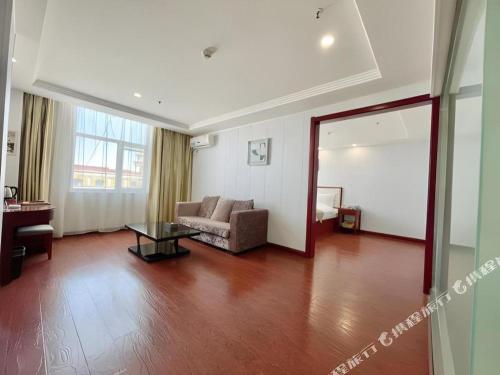 a living room with a couch and a table at GreenTree Inn Yinchuan Pedestrian Street East Liqun Street Express Hotel in Yinchuan