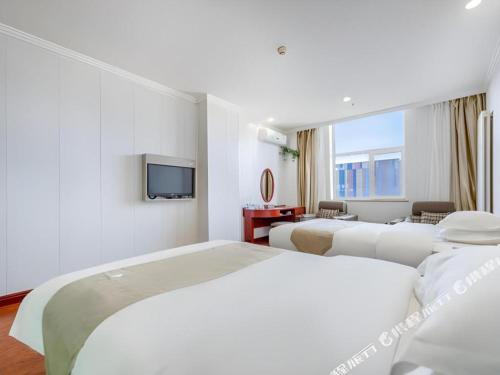 a hotel room with two beds and a television at GreenTree Inn Yinchuan Pedestrian Street East Liqun Street Express Hotel in Yinchuan