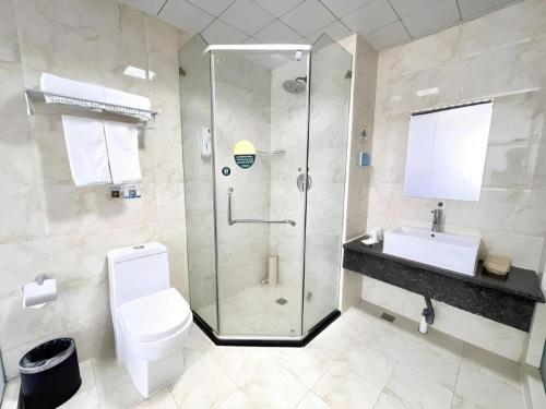 a bathroom with a shower and a toilet and a sink at GreenTree Inn Yinchuan Pedestrian Street East Liqun Street Express Hotel in Yinchuan