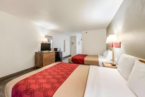 a hotel room with two beds and a television at Econo Lodge Truman Inn in Sedalia