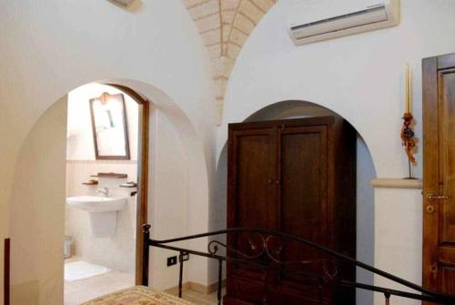 Un baño con lavabo y puerta de madera. en I Trulli Del Nonno Michele, en Alberobello