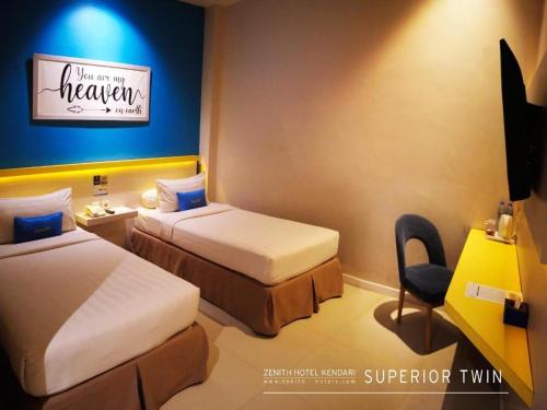 a hotel room with two beds and a chair at Zenith Hotel in Kendari