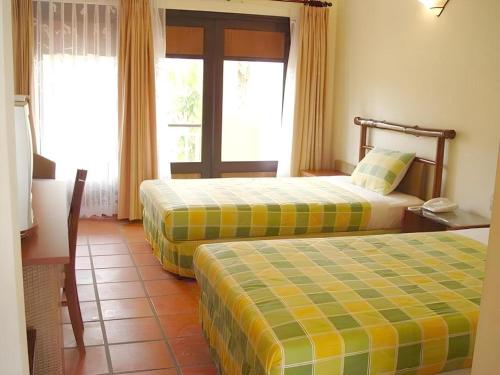 a hotel room with two beds and a window at Can Gio Resort in Can Gio