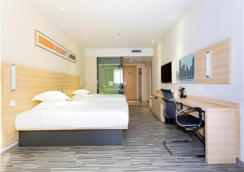 een hotelkamer met een groot bed en een bureau bij City Comfort Inn Jiangmen Xinhui Xiangshan Park in Xinhui