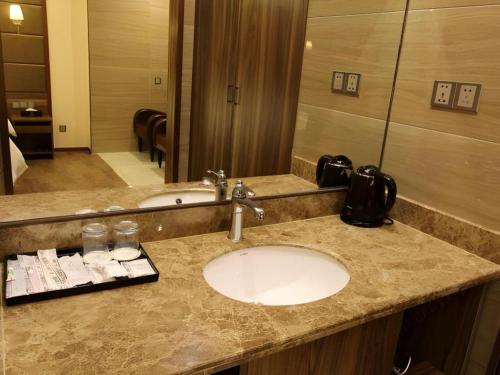 a bathroom counter with a sink and a mirror at Hanyong Hotel Shenzhen International Exhibition Center in Shenzhen
