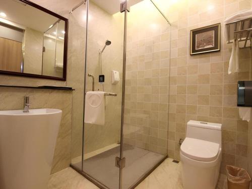 a bathroom with a shower and a toilet and a sink at Hanyong Hotel Shenzhen International Exhibition Center in Shenzhen
