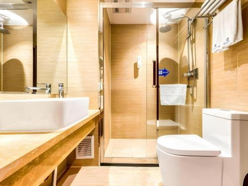 a bathroom with a sink and a toilet and a shower at Harbin Baixiang Holiday Hotel in Harbin