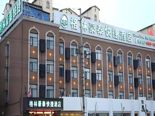 a building with a sign on the side of it at GreenTree Inn Anhui Bozhou West Guangming Road Tangwang Avenue Shall Hotel in Bozhou