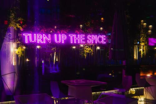 a neon sign that says turn up the spice at W Chengdu in Chengdu