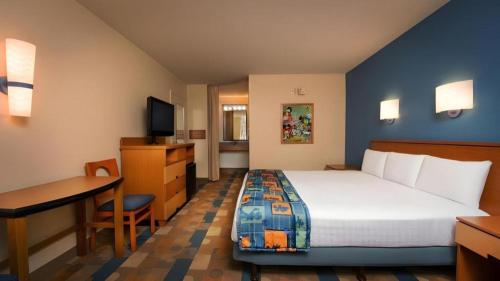 a hotel room with a bed and a desk and a computer at Disney's Pop Century Resort in Orlando