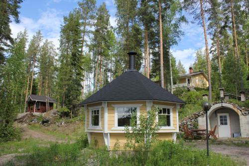 a small yellow house with a black roof at Lake Cottage Jänisvaara in Kolinkylä