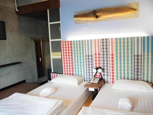 a room with two beds and a table in it at Cactus Resort & Hotel in Khon Kaen