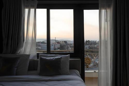 a bedroom with a bed and a large window at Gold View Boutique Hotel Đà Lạt in Da Lat