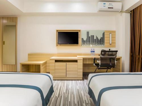 a room with two beds and a desk with a tv at City Comfort Inn Zhaoqing Qixingyan Scenic Area Xinghu Archway in Zhaoqing