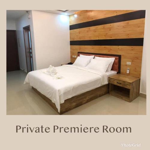 a bedroom with a large bed with a wooden headboard at Hotel Primera in Zamboanga
