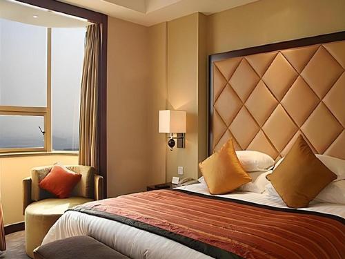 a hotel room with a large bed and a window at New Century Shaoxing Grand Hotel in Shaoxing