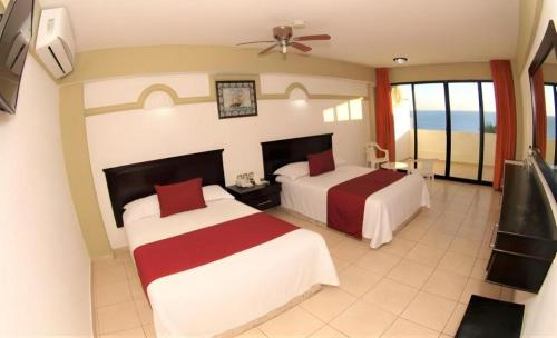 a hotel room with two beds and a balcony at Hotel Playa Bonita in Mazatlán