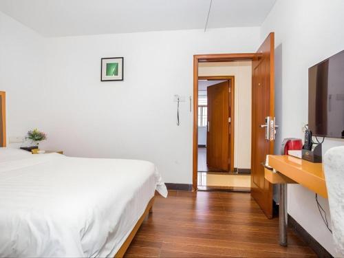 a bedroom with a bed and a television and a desk at shenzhen kaixin Hotel in Shenzhen